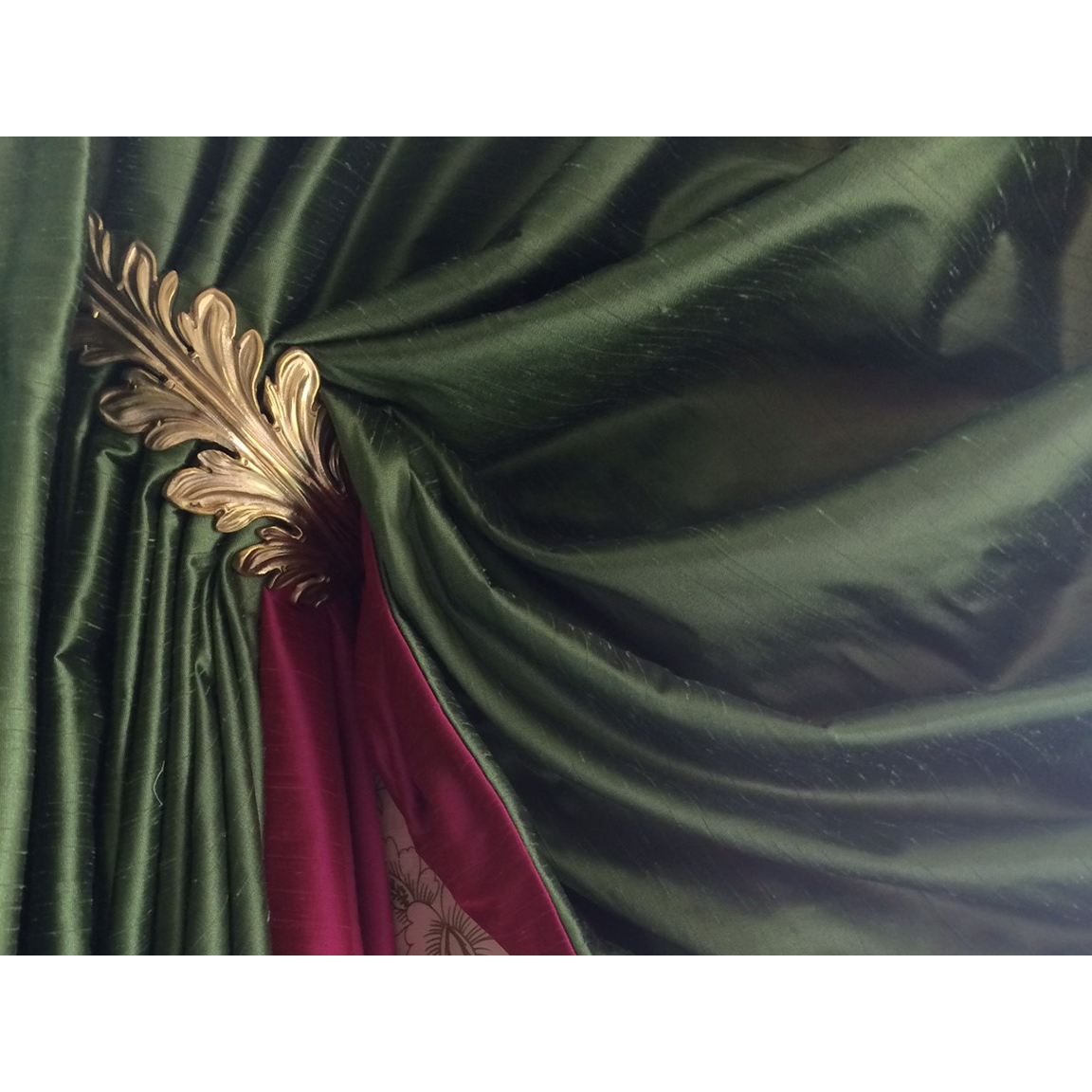 golden metal leaf holding red and purple curtains
