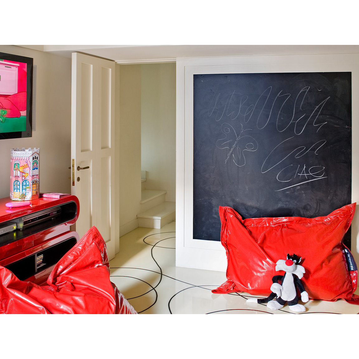 kids bedroom with big red pillows and a blackboard